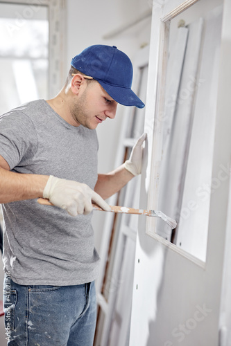 Young adult man working on a DIY budget renovation of his new home apartment.