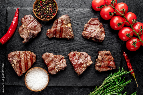 several mini Grilled beef T-bone steaks on stone background