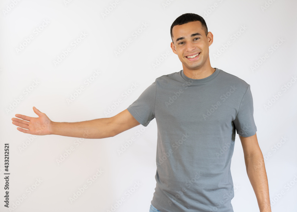 Young handsome man in casual t-shirt showing with a hand product isolated over white background. Young handsome man in casual t-shirt showing with a hand product isolated over white background.