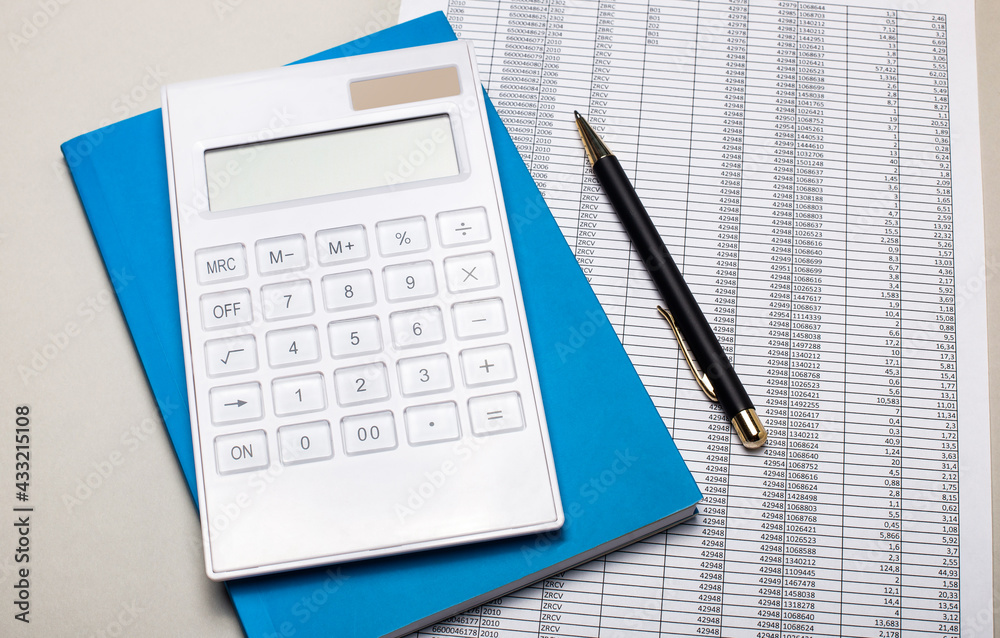 On a light gray table are reports, a blue notebook, a pen, and a white calculator. Business concept On a light gray table are reports, a blue notebook, a pen, and a white calculator. Business concept