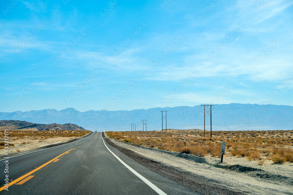 Desert scenic road in Death Valley with mountain backdrop, California, USA. Amazing panorama of desert Desert scenic road in Death Valley with mountain backdrop, California, USA. Amazing panorama of desert