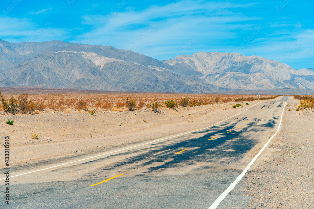 Desert scenic road in Death Valley with mountain backdrop, California, USA. Amazing panorama of desert Desert scenic road in Death Valley with mountain backdrop, California, USA. Amazing panorama of desert