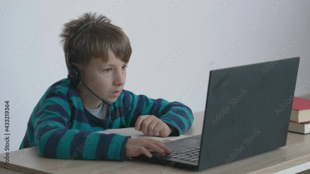 Portrait of child with headphones work at laptop, internet learning, home schooling Portrait of child with headphones work at laptop, internet learning, home schooling