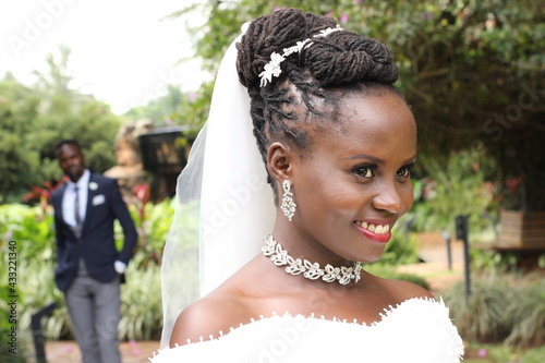 The African American brown lady happy on her wedding day in the church gardens for  a photo shoot 