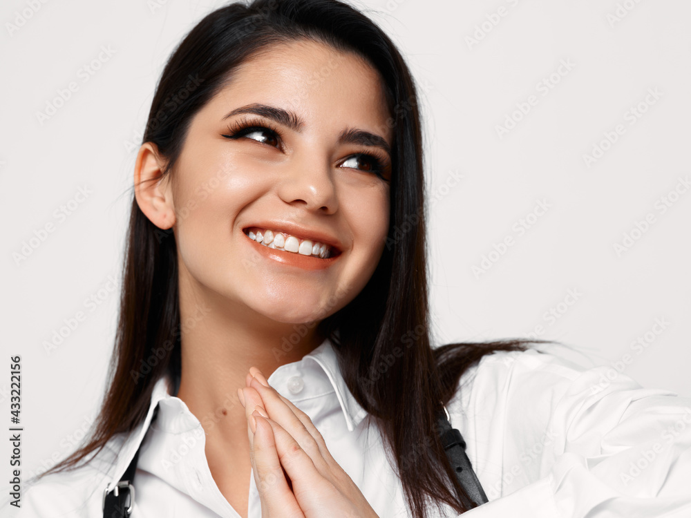 happy brunette in white shirt smiling on light background happy brunette in white shirt smiling on light background