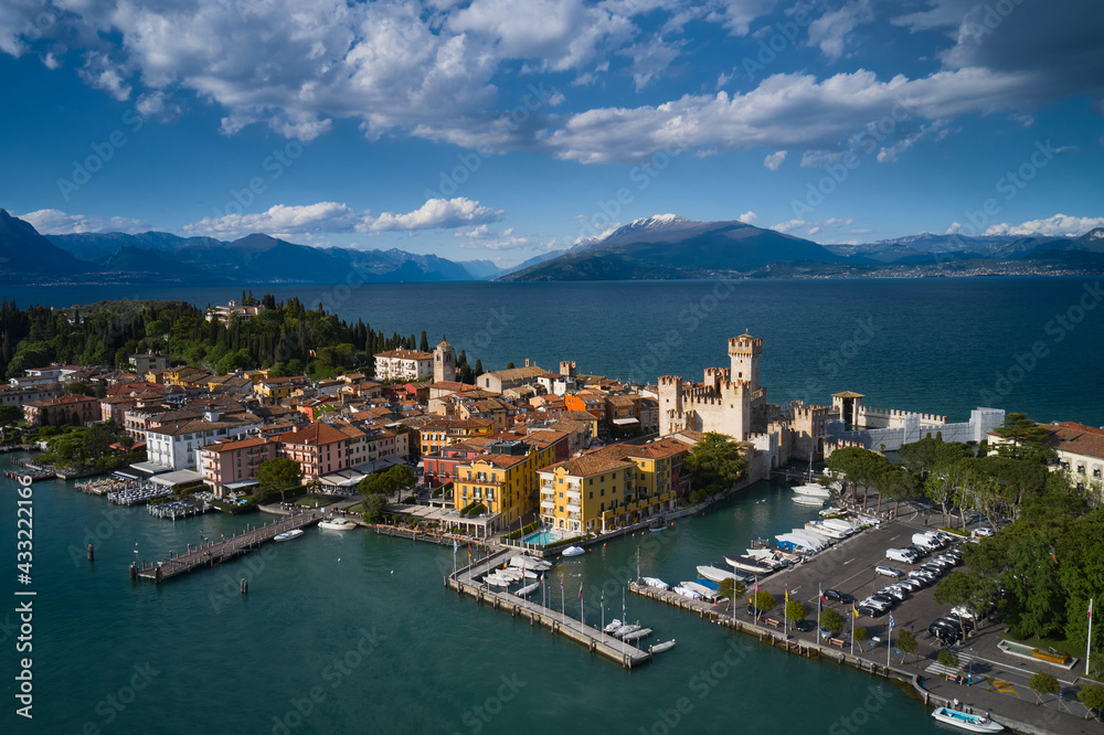 Aerial view of the island of Sirmione. Sirmione, Lake Garda, Italy. Panorama of Lake Garda. Castle on the water in Italy. Peninsula on a mountain lake in the background of the alps.