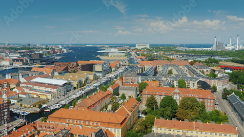Beautiful city of Copenhagen, view from the heights. Houses with tiled roofs and a river. Pan shot