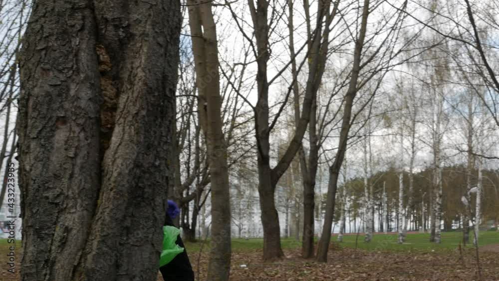 A The boy in the park has removed the waste and is carrying it for disposal.volunteer walks down the street with a package of collected garbage and waste. . High quality 4k footage