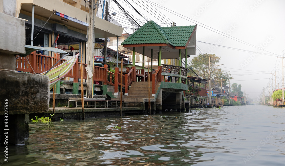 Damnoen Saduak Channel. Houses and boats in the water
