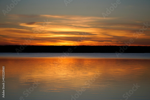 Sunset on the Plavno lake in the Berezinsky nature reserve. Horizon and reflection. Red paints a bright sky. Belarusian landscape. 