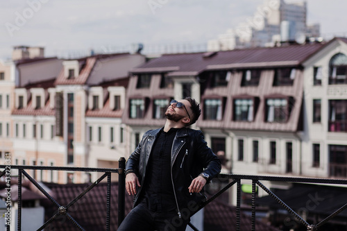 happy man in a leather jacket relaxing in a European city