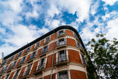 Luxury residential brick buildings in central Madrid. Low angle view of the facade against sky. Rent, market and real estate investment