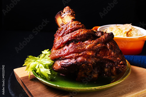 Food concept German pork hock or pork knuckle with sauerkraut cabbage pickle on wooden board with copy space