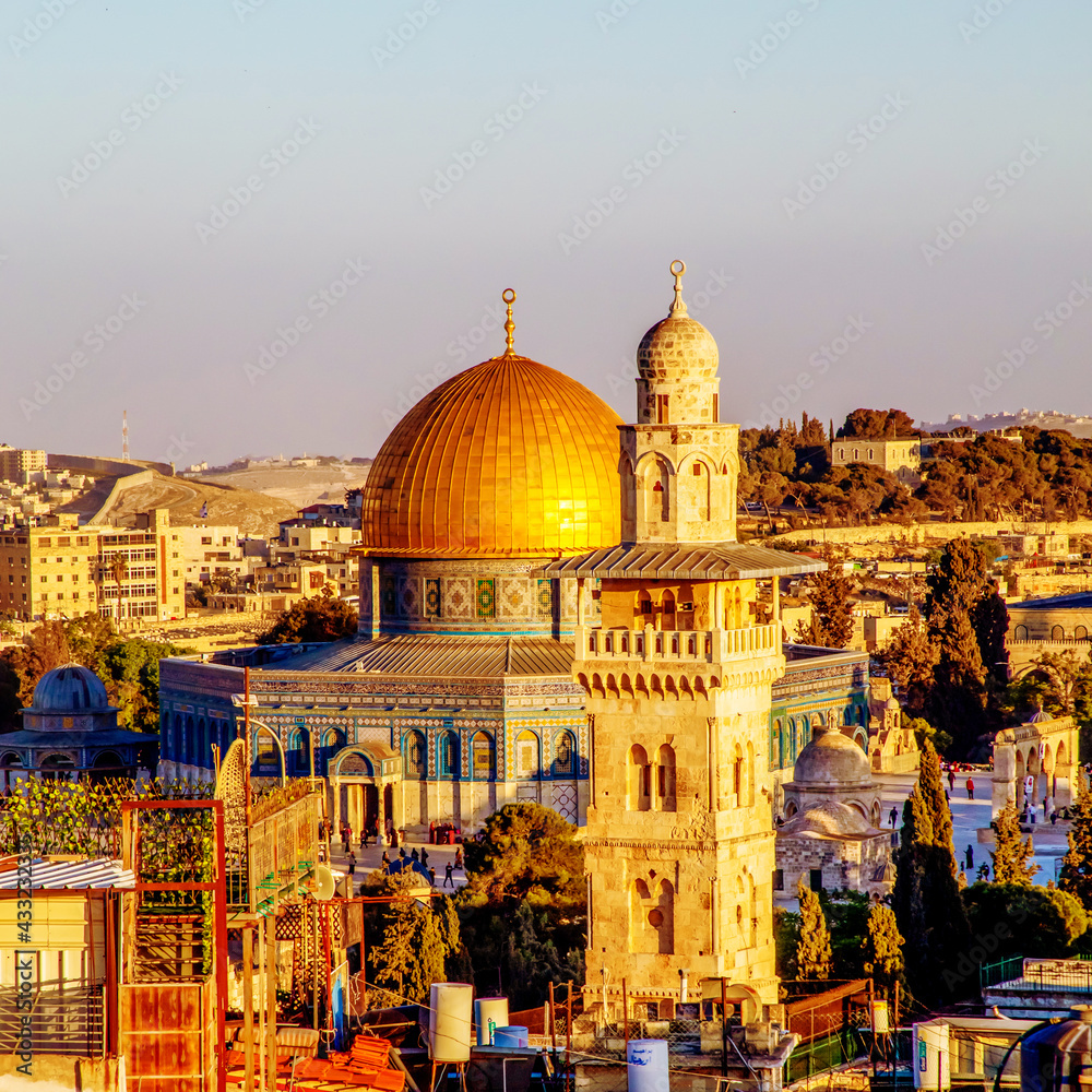 Fototapeta premium The Dome of the Rock, Islamic shrineand Al-Ghawanimah Minaret (Bani Ghanim Minaret), Temple Mount in the Old City of Jerusalem, and the rooftops of the old town houses on sunset