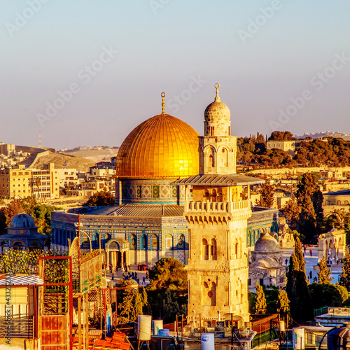 The Dome of the Rock, Islamic shrineand Al-Ghawanimah Minaret (Bani Ghanim Minaret), Temple Mount in the Old City of Jerusalem, and the rooftops of the old town houses on sunset