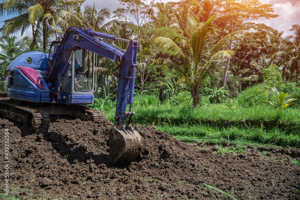 Obraz premium industrial bulldozer excavate ground and soil in tropical rain forest
