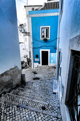 Narrow and colorful streets of Lisbon in a cloudy day photo