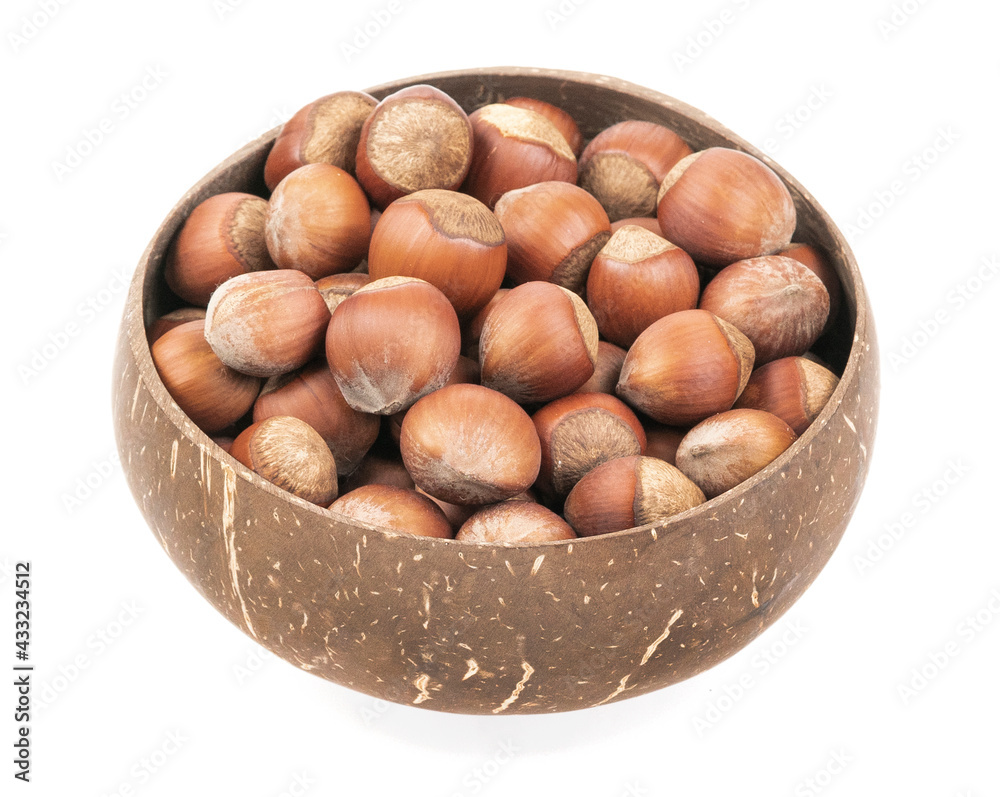 Unpeeled hazelnuts in a cup isolated on white background. hazelnuts in shell Unpeeled hazelnuts in a cup isolated on white background. hazelnuts in shell
