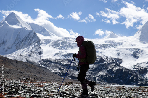 Woman backpacker hiking in winter high altitude mountains