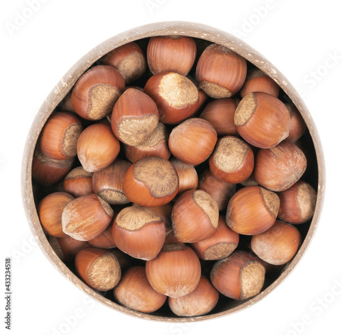 Unpeeled hazelnuts in a cup isolated on white background. hazelnuts in shell