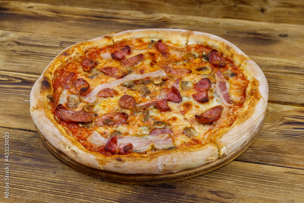 Delicious fresh pizza with sausage, mushrooms and cheese on a wooden table