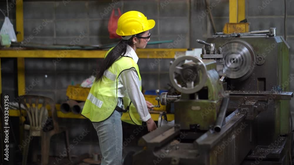 asian worker woman wearing helmet and safety glasses working with machine in factory . industrial engineer female operating lathe machine asian worker woman wearing helmet and safety glasses working with machine in factory . industrial engineer female operating lathe machine