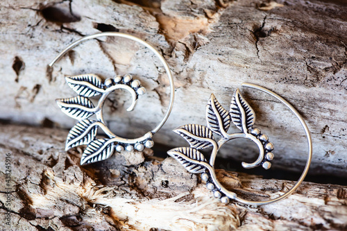 Silver metal decorative oriental spirale design earrings on natural neutral background © marbenzu