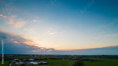 Aerial view of an evening sky over the fields overcast with thunder storm clouds coming in on the sunrise or sunset, taken with drone. High quality photo