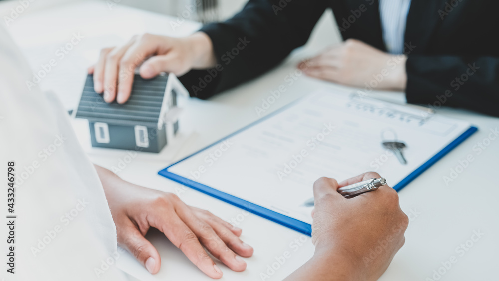 Hand signing on contract after the real estate agent explains the business contract, rent, purchase, mortgage, loan, or home insurance to the buyer. Hand signing on contract after the real estate agent explains the business contract, rent, purchase, mortgage, loan, or home insurance to the buyer.