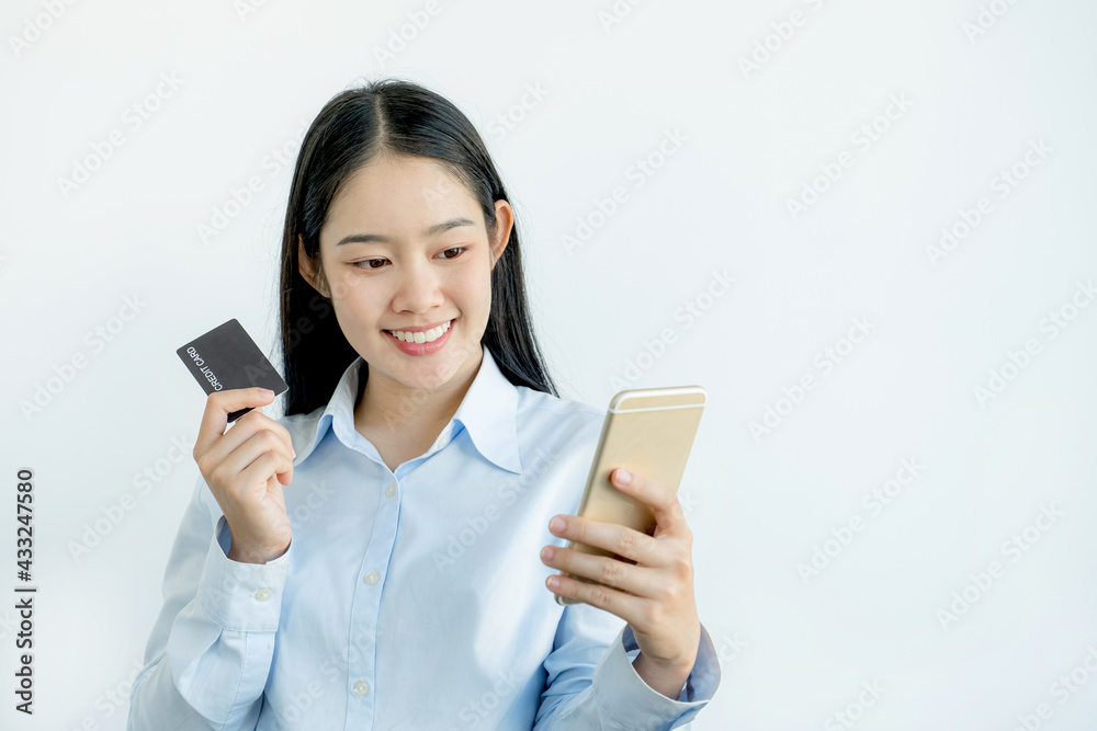 Businesswoman holding and use credit card to online shopping from home with smartphone, payment e-commerce, internet banking, spending money for next holidays Businesswoman holding and use credit card to online shopping from home with smartphone, payment e-commerce, internet banking, spending money for next holidays