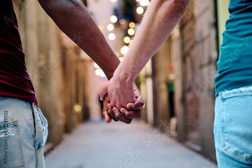 interracial love couple holding hands in outdoor location - multiethnic concept