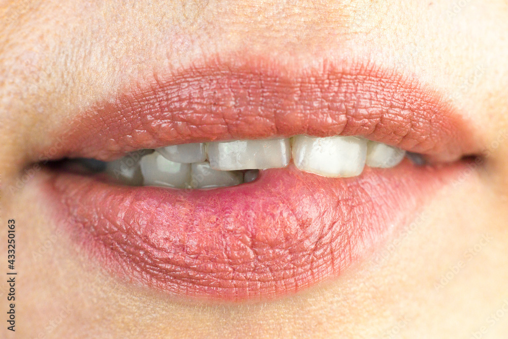 Girl sexually bites her lip with her teeth, macro photography. Stock
