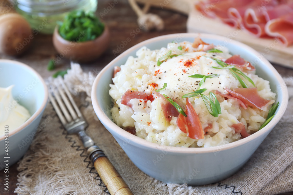Creamy risotto with parma ham (or prosciutto di Parma), green onion dressing, rustic style Creamy risotto with parma ham (or prosciutto di Parma), green onion dressing, rustic style