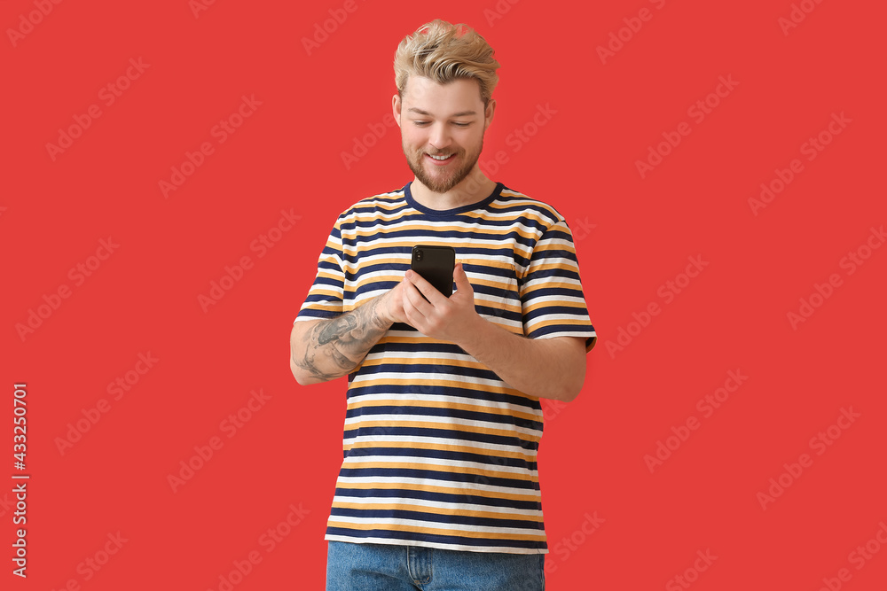 Young man with mobile phone on color background