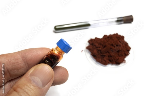 On a white background is shown the reagent for developing fingerprints called sangre de drago in powder form and in liquid form dissolved in a vial, in medicine it has healing properties. 