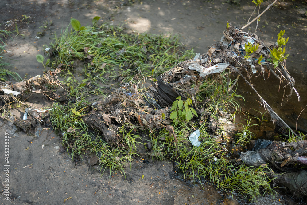 garbage, plastic bags and waste on industrial city river after spring flood garbage, plastic bags and waste on industrial city river after spring flood