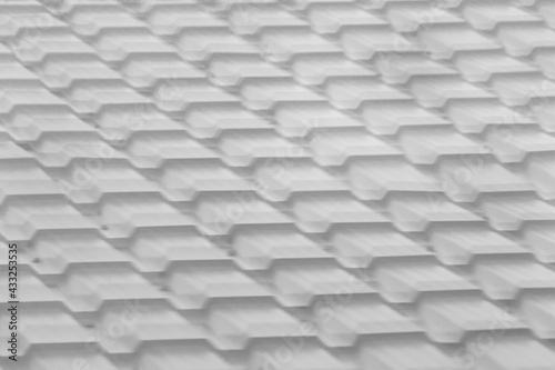 The texture of the background is gray with a rhythmic pattern of metallic metal reflected in the glass. Reflecting the modern roof roof in black white. A repetitive diagonal abstract pattern.