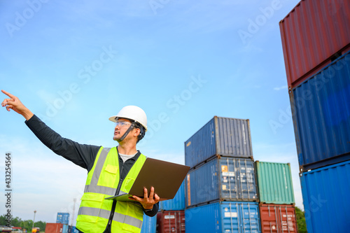 Engineer talking to a young Asian foreman work in freight industry transport and logistics concept 