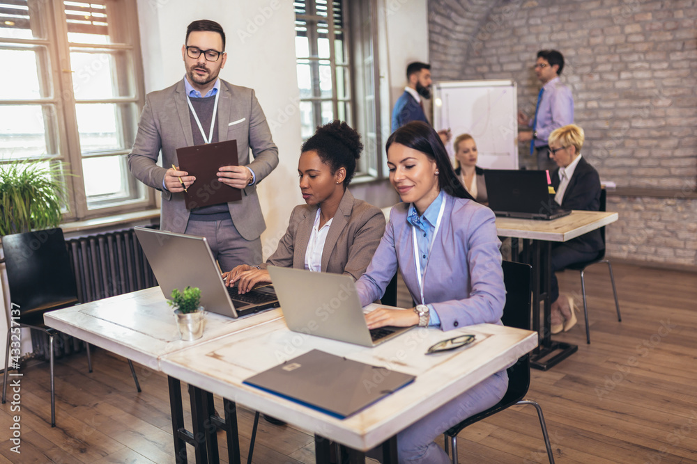 Creative diverse colleagues team discuss online project use computer at workplace