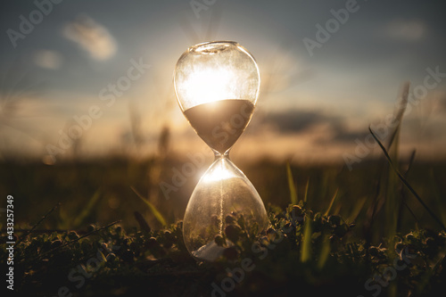 Life time passing concept. Hourglass at sunset time. concept time is money.