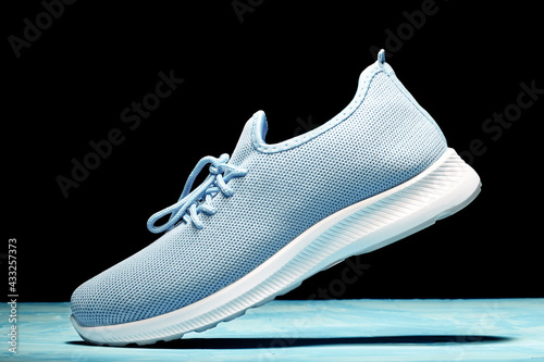 Women's textile sneaker casts a shadow in motion. Movement and lightness concept