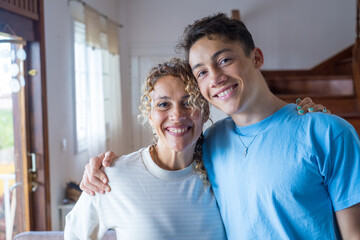 Portrait of grateful teenager man hug smiling middle-aged mother show love and care, thankful happy grown-up son in embrace cheerful mom, enjoy weekend family time at home together, bonding concept
