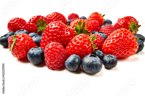 Strawberries, raspberries and blueberries on a white background.