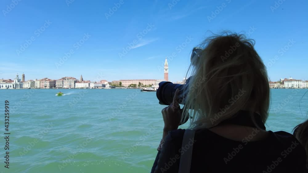 girl photographing San Marco bell tower and San Marco square in Venice with Saint Mark Basilica of the famous Venetian city of Italy. Giudecca canal by cruise boat trip in Venetian lagoon. girl photographing San Marco bell tower and San Marco square in Venice with Saint Mark Basilica of the famous Venetian city of Italy. Giudecca canal by cruise boat trip in Venetian lagoon.
