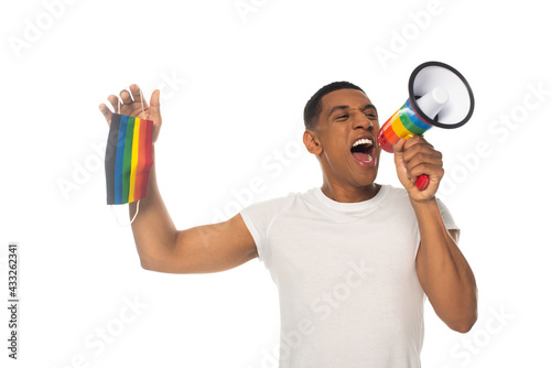 african american man holding lgbt colors medical mask while screaming in megaphone isolated on white © LIGHTFIELD STUDIOS