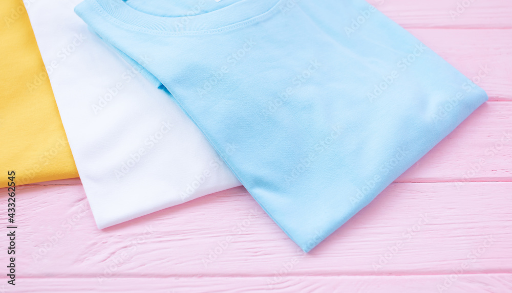 Top view of color t-shirt on wood plank background. Top view of color t-shirt on wood plank background.
