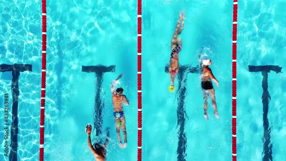 Overhead view of group of young swimmers training in swimming pool with marked lanes outdoor. Many sportive people and kids swim in Open Water Swimming pool with clean blue water. Summer sports camp