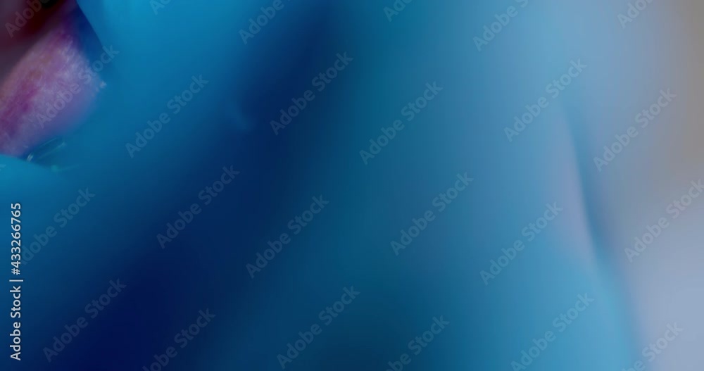 Close-up an orthodontist hand in blue gloves is putting green ligature ties on braces with a multiloop edgewise archwire of an upper jaw by using dental forceps.