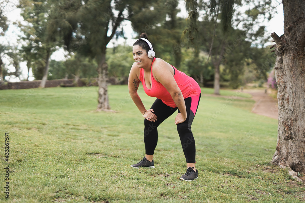 Plus size woman doing sport workout at city park - Curvy girl and healthy lifestyle concept Plus size woman doing sport workout at city park - Curvy girl and healthy lifestyle concept