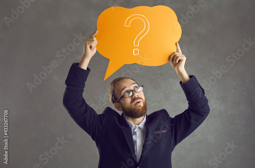 Foto Serious sceptical smart young business man in glasses with dubious judging evalu